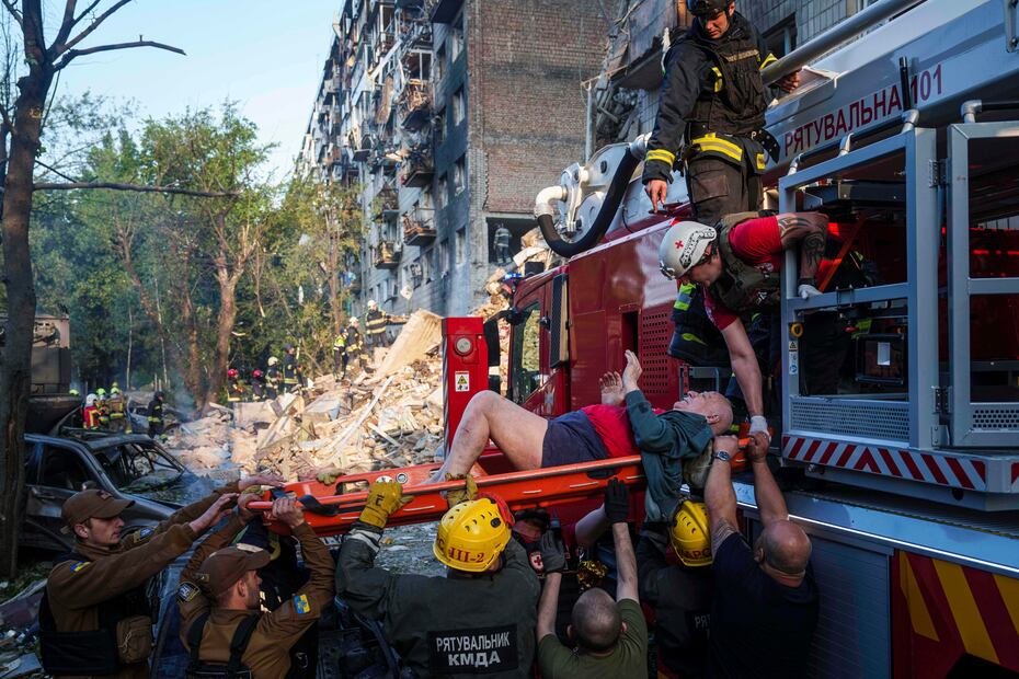 Los rescatista evacuan a un hombre herido en los ataques de Rusia en la capital ucraniana. (AP Photo/Evgeniy Maloletka)