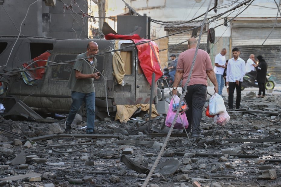 Un hombre carga sus pertenencias mientras abandona el lugar de los edificios destruidos que fueron alcanzados en ataques aéreos israelíes en la ciudad portuaria sureña de Tiro, Líbano.
