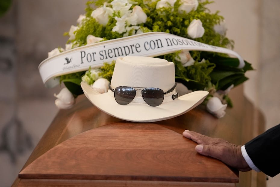 El sombrero y las gafas de sol del cantante dominicano Rubby Pérez, quien murió en el derrumbe del techo del club nocturno Jet Set durante su concierto de merengue, se encuentran sobre su ataúd durante su velorio en el Teatro Nacional Eduardo Brito en Santo Domingo, República Dominicana, el jueves 10 de abril de 2025. (AP Photo/Matias Delacroix)