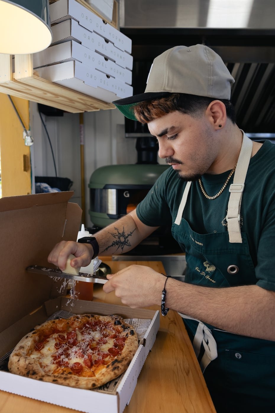 En un tráiler, dos hornos híbridos –de leña y gas– arden a 900°F. Caramelizan las pizzas en 90 segundos.