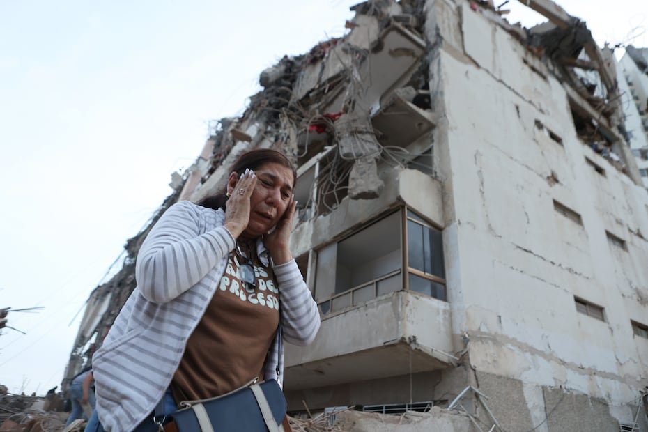 Una mujer pasa junto a un edificio dañado durante un terremoto en La Guaira.