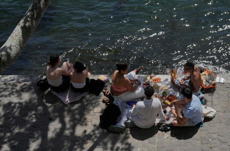Varias personas disfrutan de un picnic a orillas del río Sena durante un día soleado, el lunes, 25 de mayo de 2026, en París. Una ola de calor primaveral continuaba el martes azotando partes de Europa Occidental.
