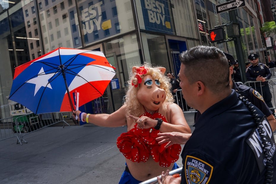 Una persona con una máscara de Miss Piggy pide indicaciones a unos agentes de la policía de Nueva York.