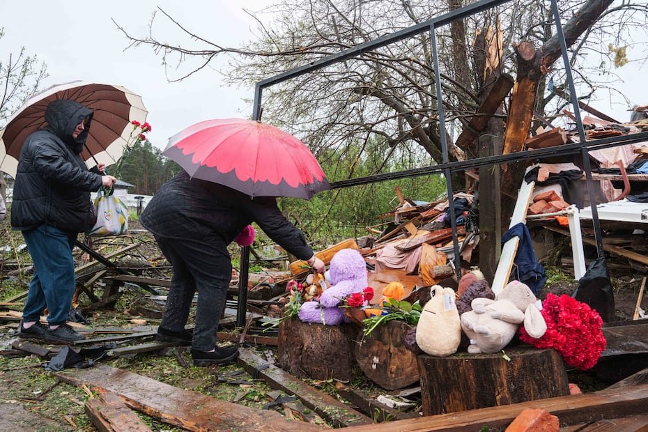 Women put flowers to the rubble of a destroyed house where three children were killed by a Russian strike in Korostyshiv, Zhytomyr region, Ukraine, Sunday, May 25, 2025. (AP Photo/Evgeniy Maloletka)