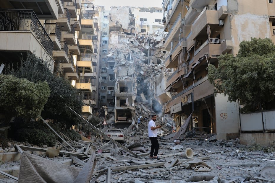 Un hombre inspecciona el lugar de los edificios destruidos que fueron alcanzados en ataques aéreos israelíes en la ciudad portuaria sureña de Tiro, Líbano.