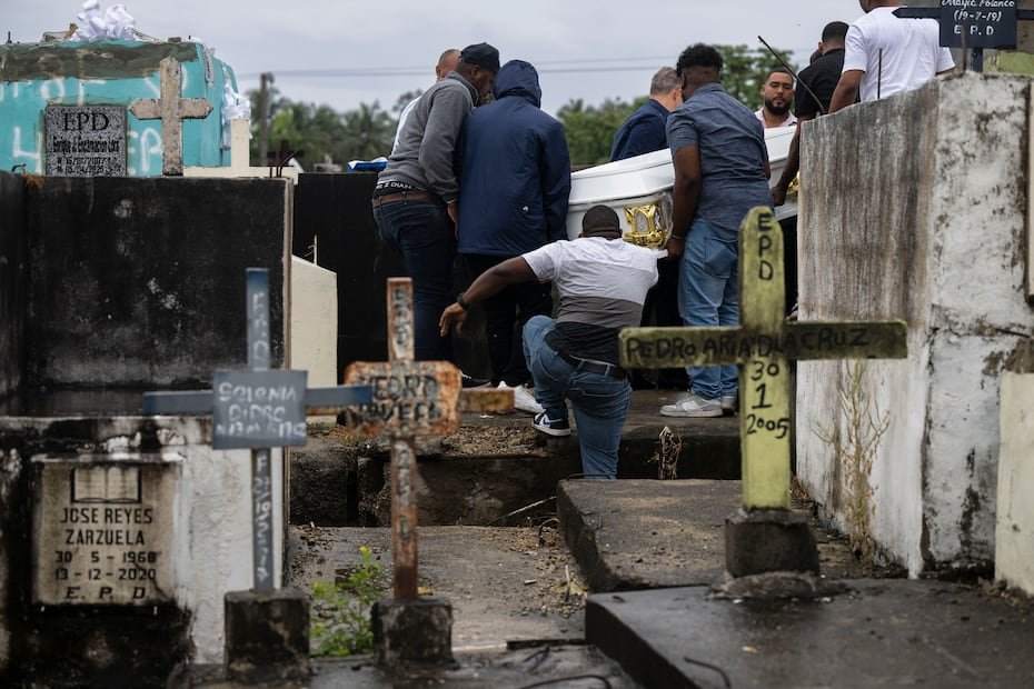 Desde el Cementerio Municipal de los Bajos de Haina, una familia llora la pérdida de sus seres queridos.