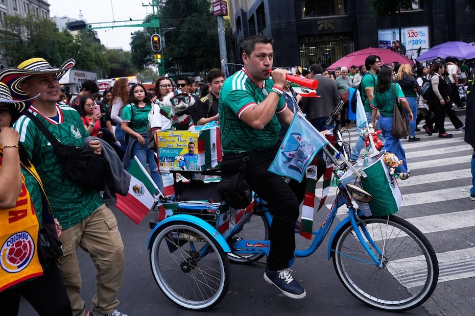 Osito es un perro rescatado de 8 años rescatado que se ha convertido en una sensación tras llegar al partido inaugural de México montado en una bicicleta, vestido con una camiseta, gafas de sol y una gorra.