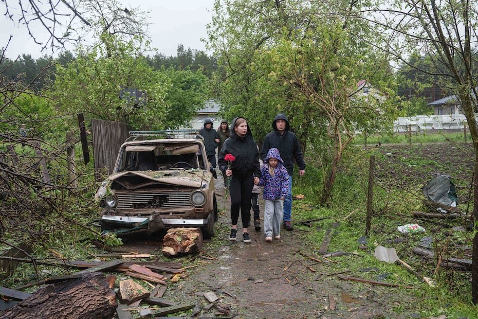 Personas llevan flores a la casa donde murieron los niños tras el ataque ruso.