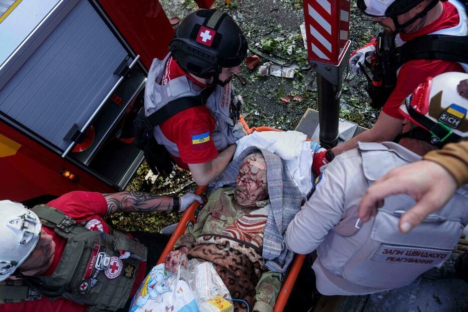Los voluntarios de la Cruz Roja evacuan a una señora lastimada de los restos del apartamento destruido por los ataques aéreos de Rusia en Kiev, Ucrania. (AP Photo/Evgeniy Maloletka)