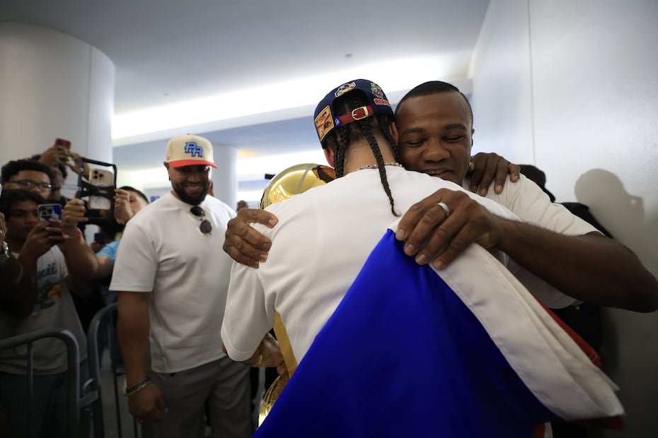 El ex boxeador Felix "Tito" Trinidad abrazó al jugador de baloncesto y luego le entregó una bandera de Puerto Rico.