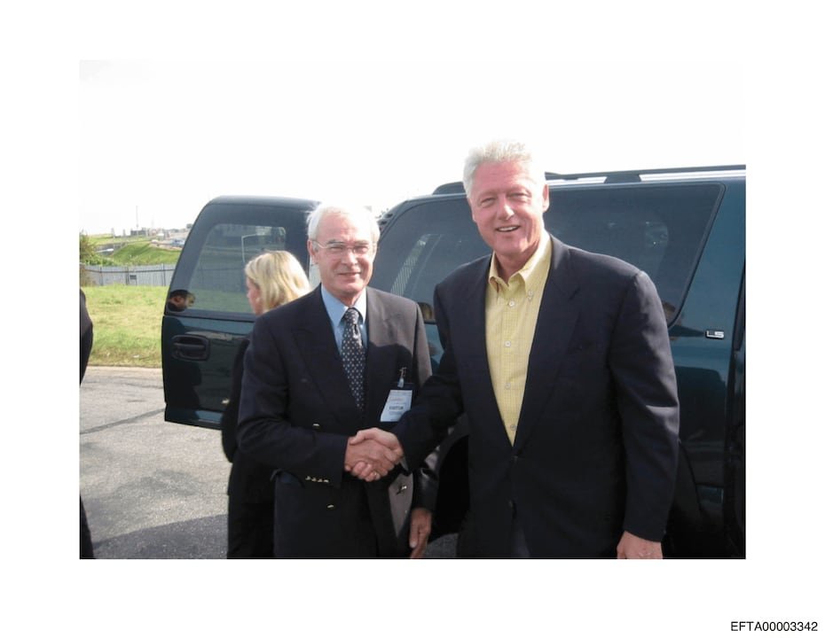 El expresidente Bill Clinton, a la derecha, estrechando la mano de un hombre desconocido.