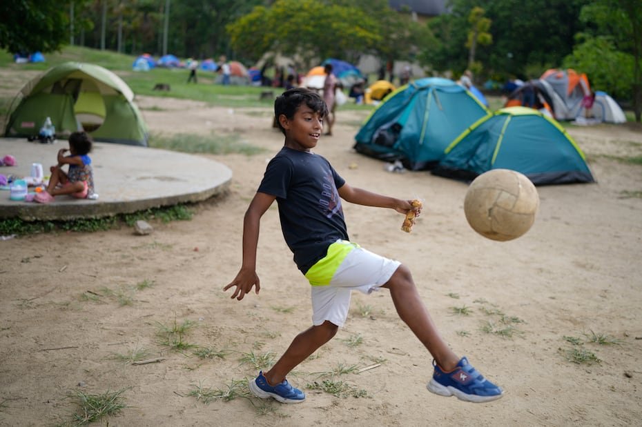 Daringer Castillo juega fútbol en el parque donde está acampando con su familia después de que su hogar resultara dañado por los terremotos que sacudieron Caracas.