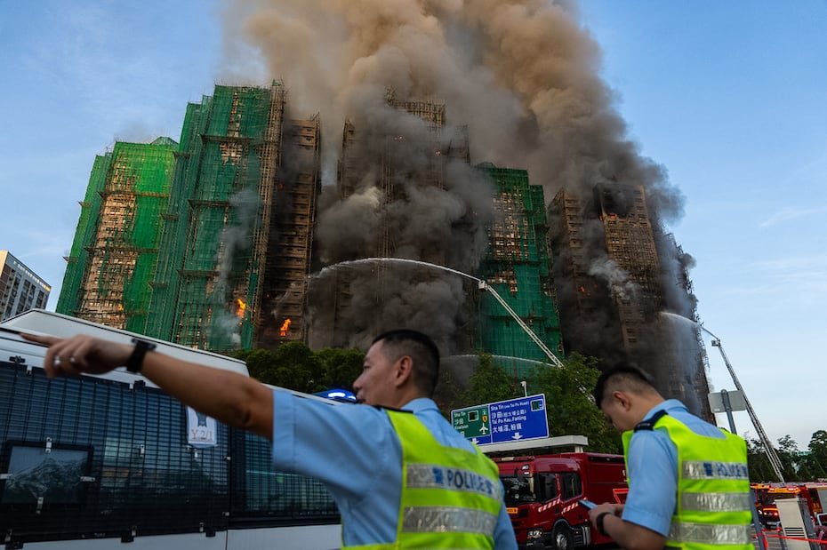 El furioso incendio provocó una columna de llamas y humo espeso mientras se propagaba por un andamio de bambú y una red de construcción que se habían instalado.
