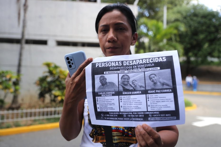 Una mujer sostiene un cartel con imágenes de sus familiares desaparecidos tras los terremotos ocurridos en Venezuela hace cinco días que han dejado 1,450 fallecidos y miles de heridos.