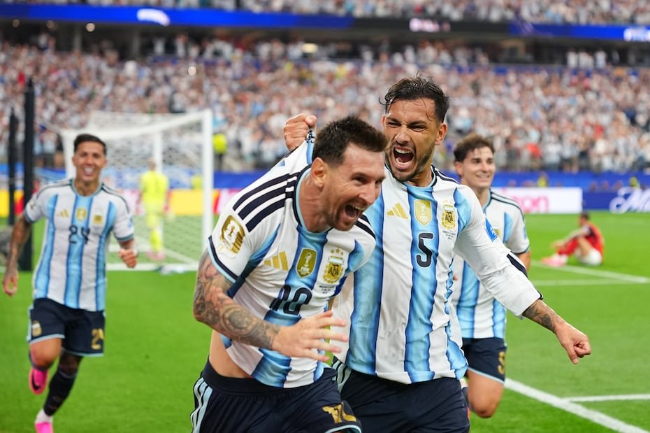 Leandro Paredes (5) agarra de la camiseta a su compañero Lionel Messi al celebrar el segundo gol de Argentina en la victoria 2-0 ante Austria.