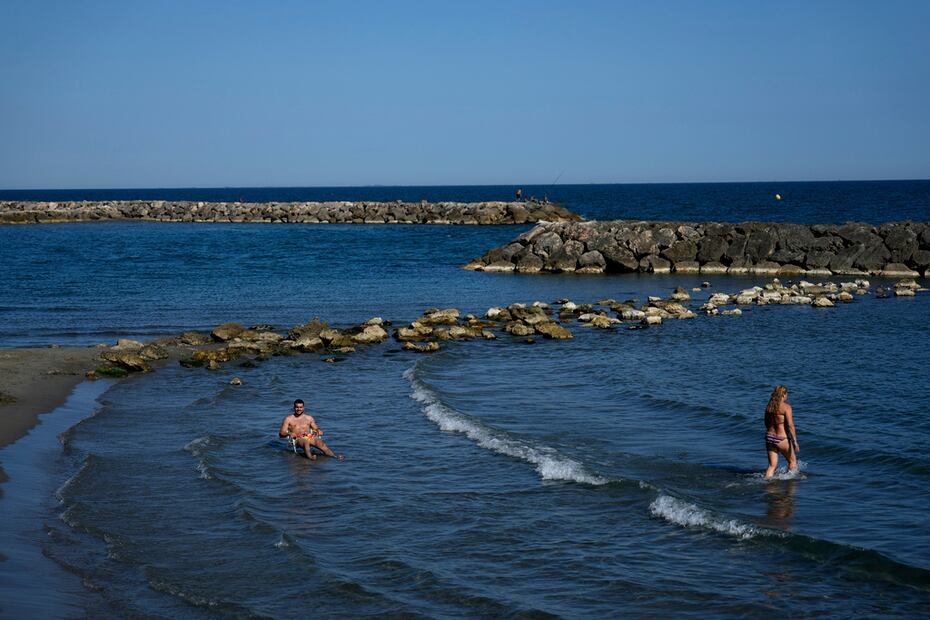 Mientras, bañistas disfrutan del mar en  Saintes-Maries-de-la-Mer, al sur de Francia.