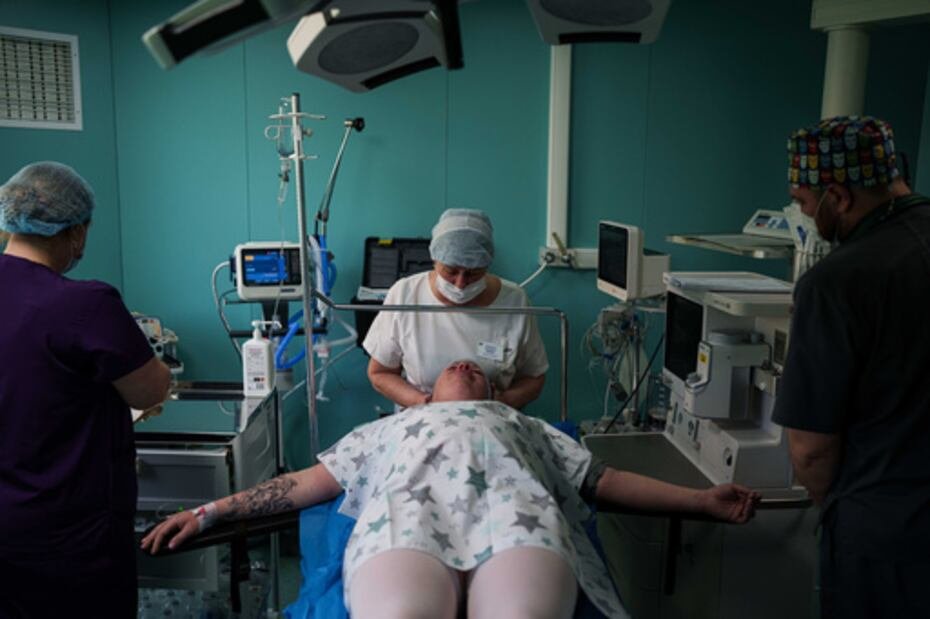Un médico calma a Olha Karpenko antes de una cesárea en el centro perinatal regional de Zaporizhzhia, Ucrania, miércoles 6 de mayo de 2026. (AP Photo/Evgeniy Maloletka)