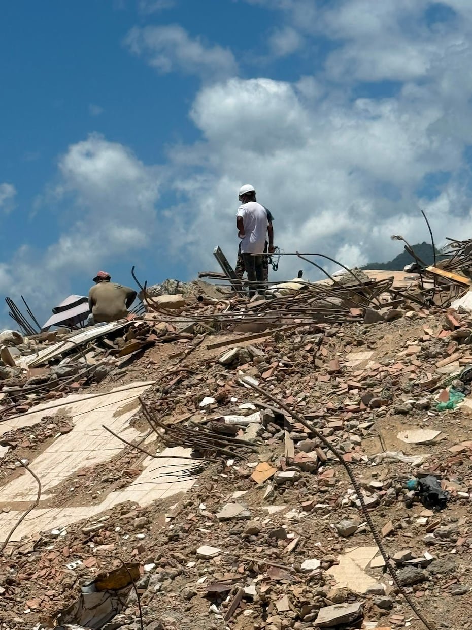 En la foto, dos personas sobre ruinas. El doblete sísmico provocó el colapso de cientos de edificios.