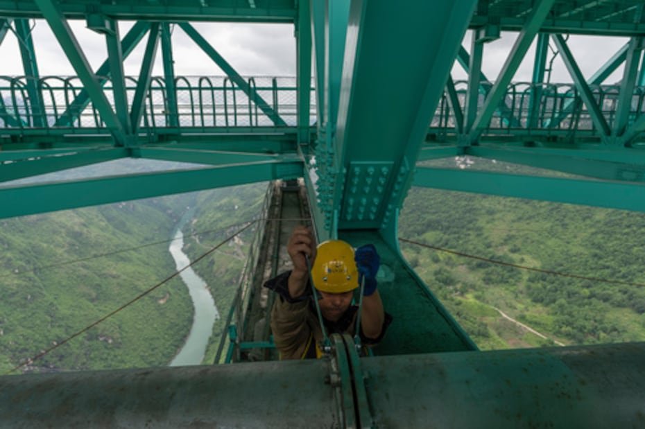Un trabajador aprieta los tornillos de una tubería del puente.
