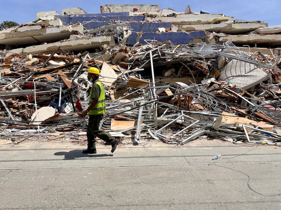 Un hombre camina frente a escombros de una edificación derrumbada por terremotos, en La Guaira (Venezuela).