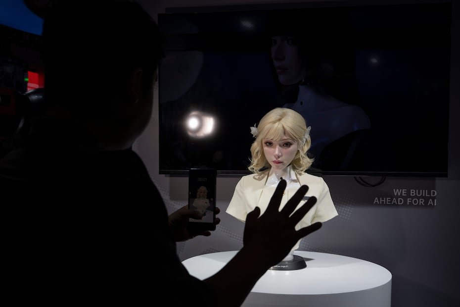 La cabeza de un robot de apariencia realista observa a un visitante durante el World AI Conference.