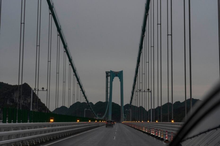 Vehículos circulan por el puente del Gran Cañón de Huajiang.