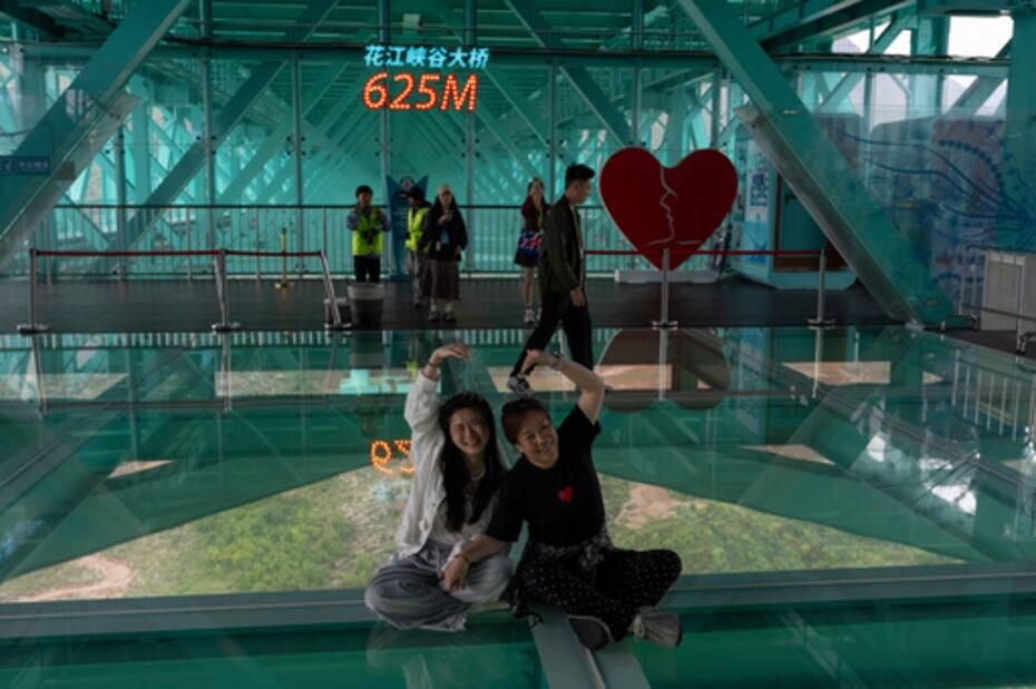 Turistas posan para hacerse fotos en el puente del Gran Cañón.