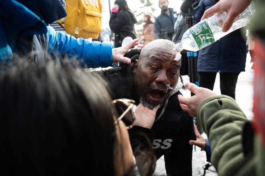 El fotógrafo King Demetrius Pendleton se lava los ojos tras ser alcanzado por sustacias químicas.