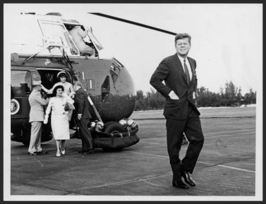 El presidente John F. Kennedy al abandonar el helicóptero que le llevó al Aeropuerto Internacional de Isla Verde, camina sonriente hacia su avión mientras a fondo, el entonces gobernador Luis Muñoz Marín y un oficial del ejército ayudan a Jackeline Kennedy a abandonar el helicóptero. También saliendo del helicóptero la entonces, primera dama, Inés Mendoza de Muñoz. Foto tomada el 18 de diciembre de 1961. (Perteneciente a la Colección de Fotos de El Mundo, Bibioteca Digital Colección Puertorriqueña, Universidad de Puerto Rico en Río Piedras.)