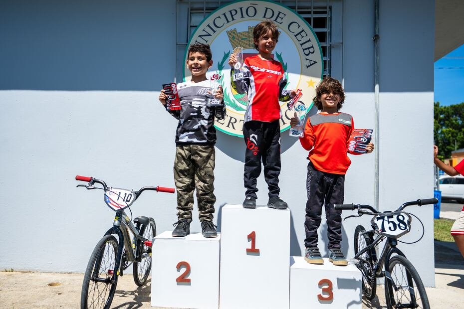 Niños sonríen en el podio de su categoría.