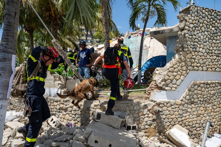 Miembros del Regimiento Francés de Entrenamiento e Intervención en Seguridad Civil llegan con su perro a un edificio dañado cerca del complejo Karting La Guaira en Caraballeda.