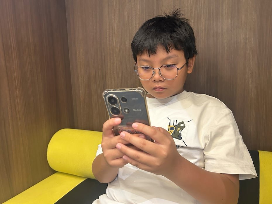Hew Chee Weng, de 11 años, usa su teléfono celular en Kuala Lumpur. Malasia es el último país de Asia-Pacífico en sumarse este lunes a la expulsión de los menores de 16 años de las redes sociales.