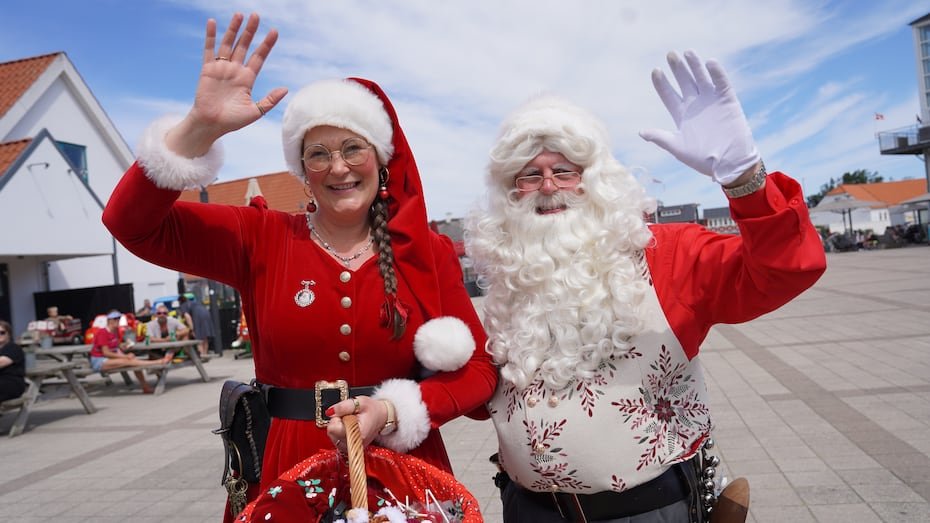 Un intérprete disfrazado de Santa Claus y otro de elfo navideño saludan a la cámara durante el Congreso Mundial anual de Santa Claus, una colorida tradición de mediados de verano, en Aalborg, Dinamarca.