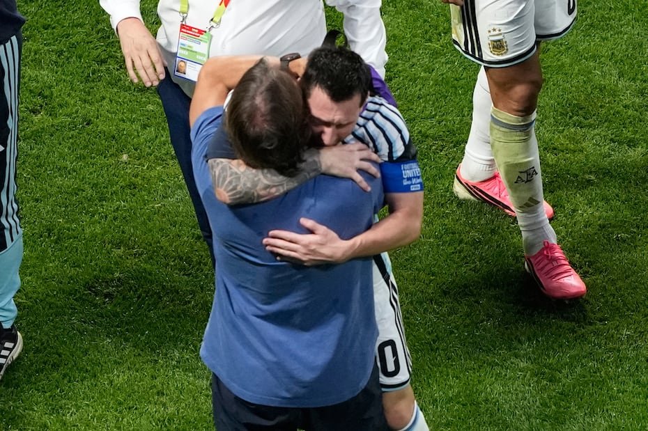 Lionel Messi se abraza con un miembro del cuerpo técnico de Argentina.