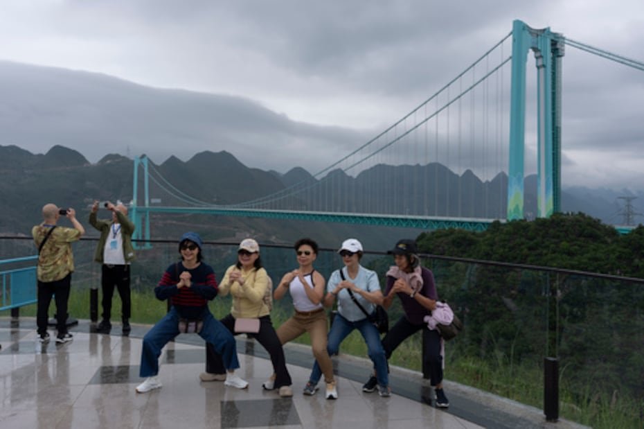 Turistas posan para hacerse fotos cerca del puente del Gran Cañón de Huajiang, considerado el puente más alto del mundo, en Anshun, en la provincia suroccidental china de Guizhou.