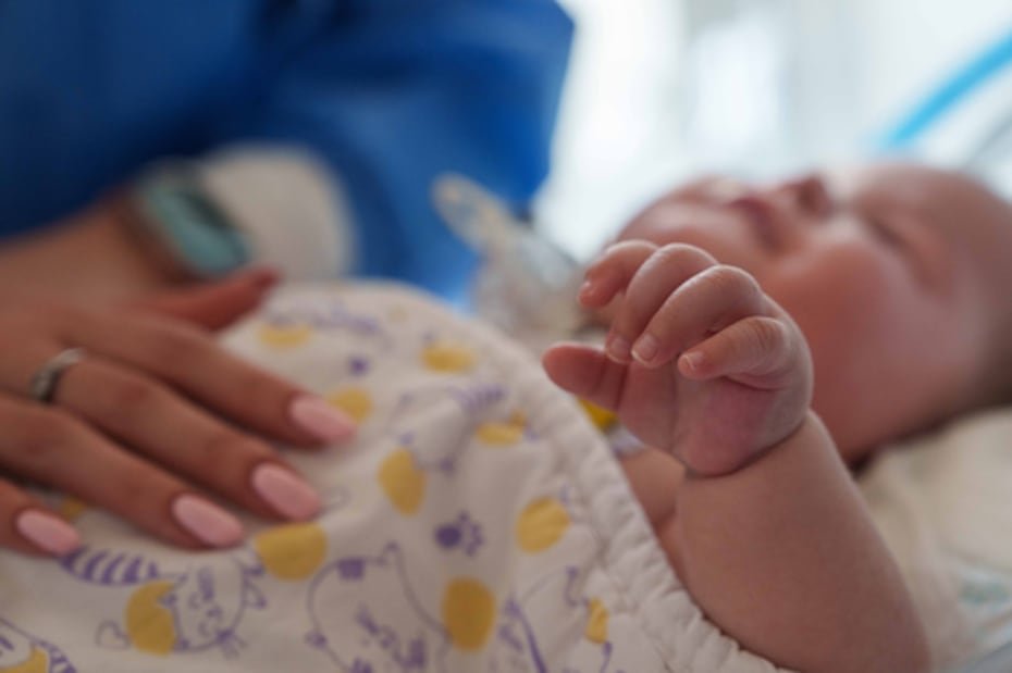 Dasha Kosmin toca a su hijo Mark en la unidad de cuidados intensivos del hospital regional infantil de Zaporizhzhia, en Ucrania.