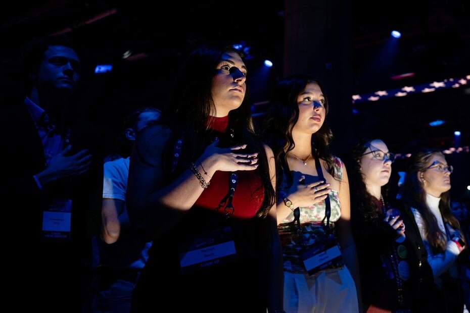 Los asistentes observan el Himno Nacional.