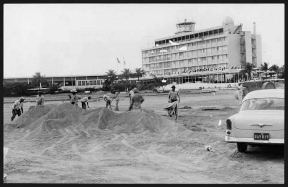 Tomada el 7 de mayo de 1964, obreros trabajaban en la construcción de estacionamientos en el AILMM. Las obras requirieron una inversión de $400,000 de fondos estatales e incluían 425 espacios adicionales para pasajeros y empleados, además de la redistribución del tránsitoen el área. (Colección de Fotos de El Mundo Bibioteca Digital Colección Puertorriqueña Universidad de Puerto Rico en Río Piedras)