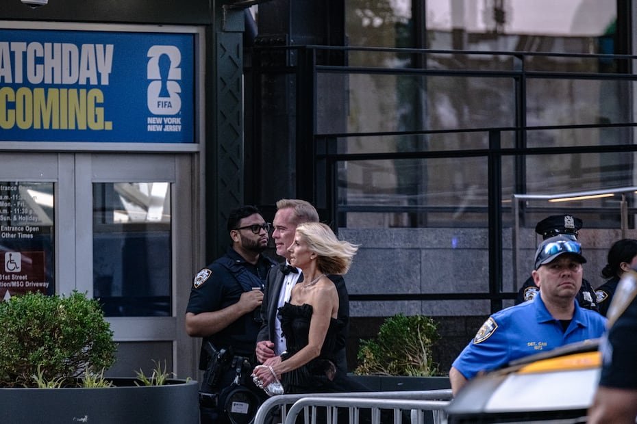 Los comentaristas deportivos estadounidenses Joe Buck (al centro) y Michelle Beisner-Buck llegan bajo fuerte seguridad a la celebración de la boda de Taylor Swift y Travis Kelce en el Madison Square Garden de Nueva York. EFE/EPA/LAURA BRETT