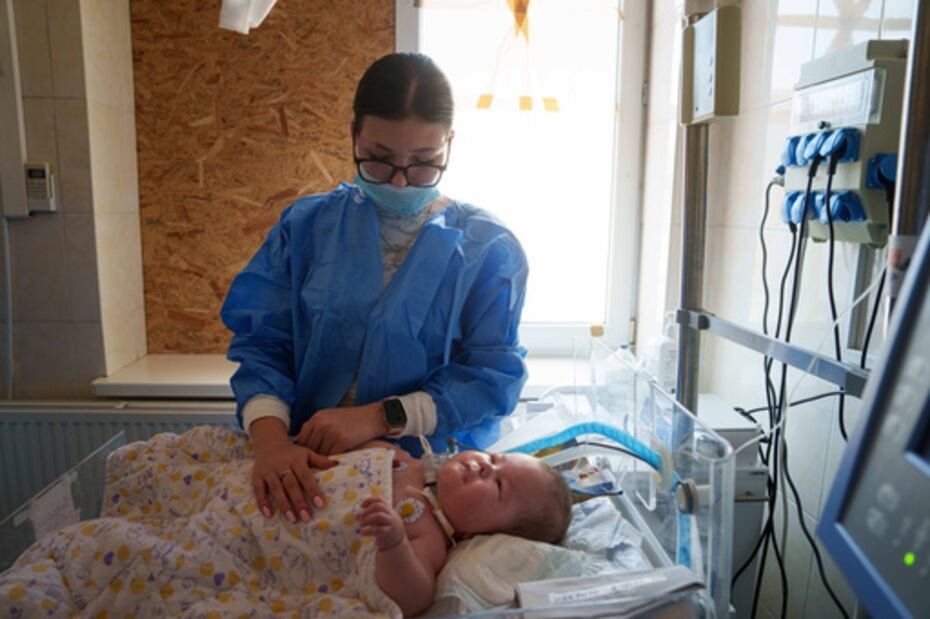 Dasha Kosmin toca a su hijo Mark en el departamento de UCI del hospital regional infantil de Zaporizhzhia.