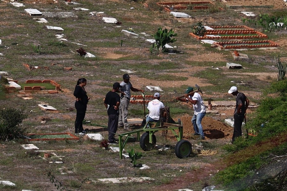 Trabajadores del cementerio preparando fosas.