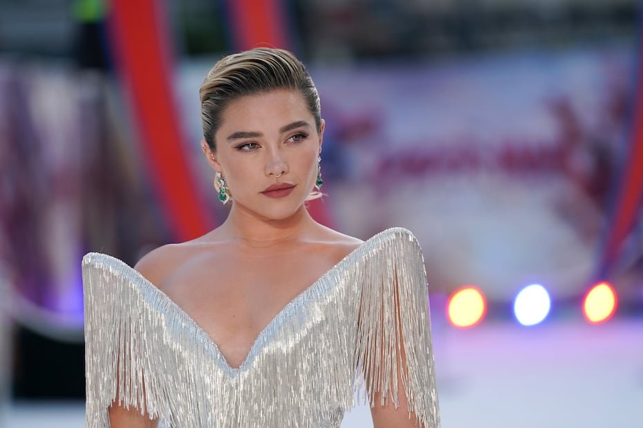 Florence Pugh lució espectacular con el vestido de flecos de canutillo plateado de Tamara Ralph, que presenta un impactante escote con diseño de alas y está adornado con cristales plateados Xillion.