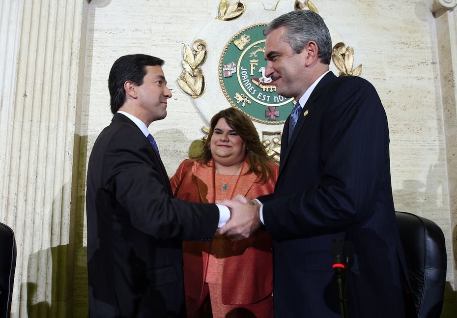 En el fondo, Jenniffer González durante el mensaje de presupuesto del año fiscal 2010-2011. Frente a ella, el entonces gobernador Luis Fortuño y el presidente del Senado en ese momento, Thomas Rivera Schatz, se saludaban.