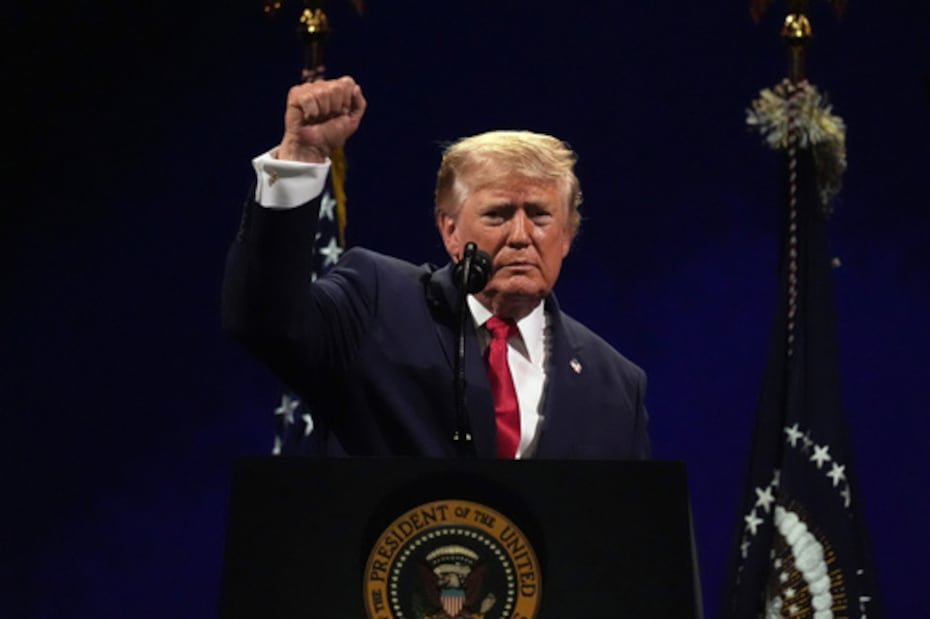 El presidente Donald Trump levanta el puño al concluir su discurso.