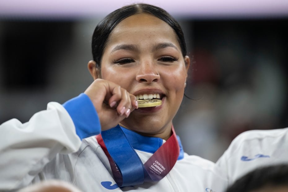 Las jugadoras puertorriqueñas muerden su medalla de oro, en la tradicional celebración de los campeones.