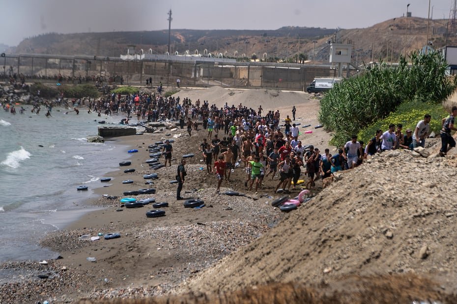 Migrants cross from Morocco into the Spanish enclave of Ceuta, Thursday, July 30, 2026. (AP Photo/Antonio Sempere)