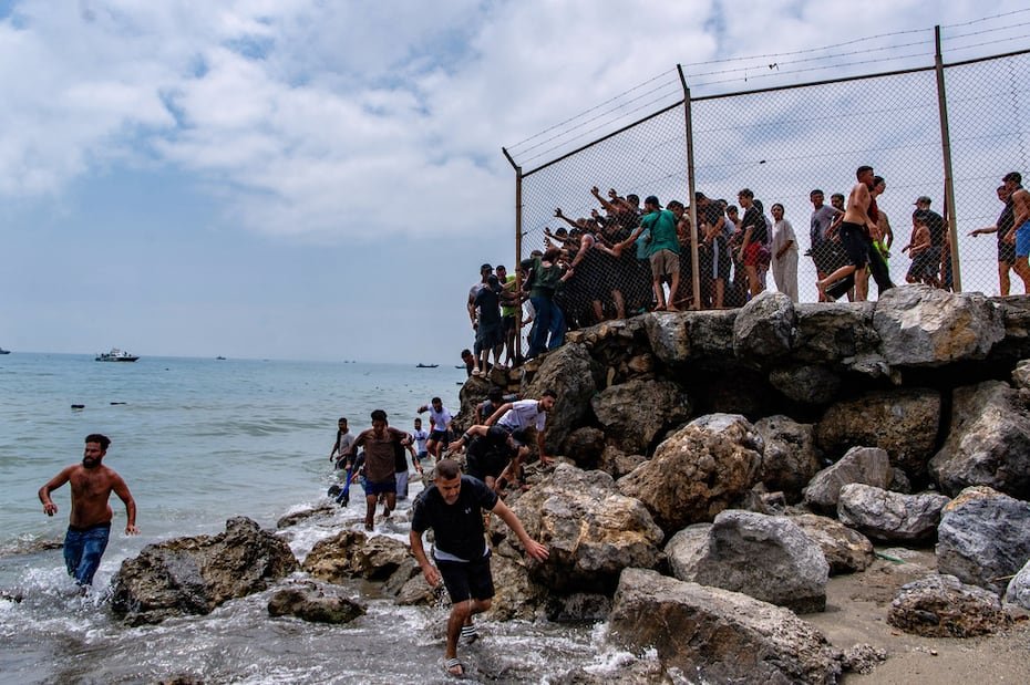 Migrants cross from Morocco into the Spanish enclave of Ceuta, Thursday, July 30, 2026. (AP Photo/Antonio Sempere)