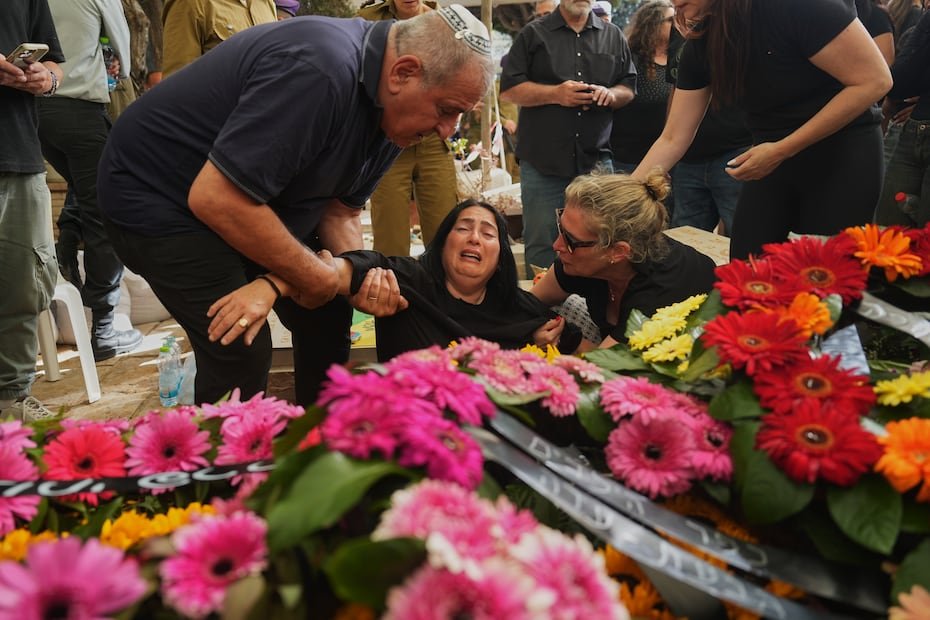Hilit, al centro, llora sobre la tumba de su hija, la soldado israelí sargento Rotem Yanai, quien murió en un ataque con drones libaneses en el norte de Israel, durante su funeral en Givat Ada, Israel.